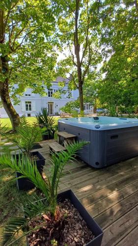 un bain à remous installé au-dessus d'une terrasse en bois dans l'établissement La Carte Postale, à Oye-Plage