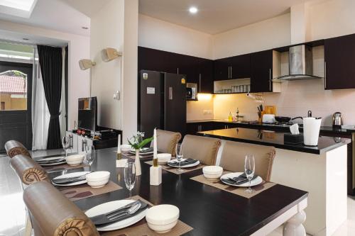 a kitchen and dining room with a table and chairs at King Family Massarossa Pool Villa Pattaya VIP in Pattaya
