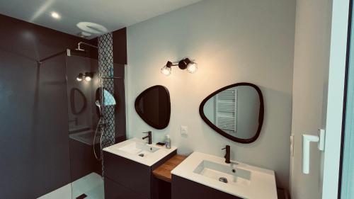une salle de bain avec deux lavabos et un miroir dans l'établissement La Garenne, piscine et pinède, à Saint-Jean-de-Monts