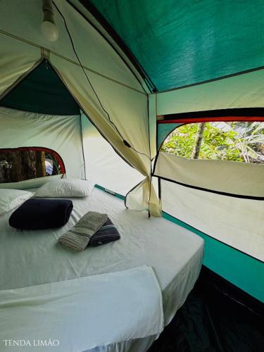 a bed in a tent with two pillows on it at Sitio Simple Life in Ubatuba
