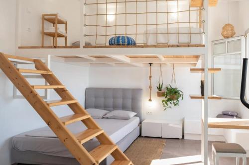 a room with a bunk bed and a ladder at Κατοικία Uppolis με θέα τα νησιά in Ano Syros