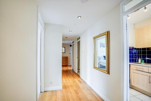 a kitchen with white walls and a wooden floor at Premier Suites Shepherds Bush Westfields Penthouse Apartment in London