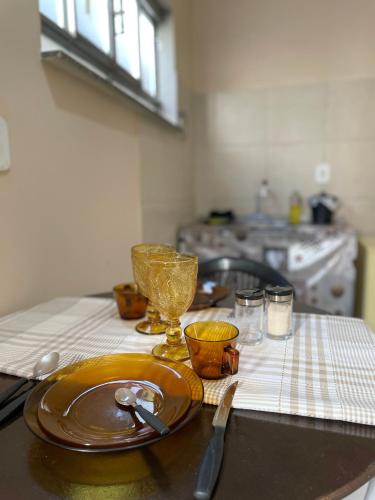 Una mesa con un plato y vasos en la encimera de la cocina. en Kitnet Prático Aconchego 2, en Petrolina
