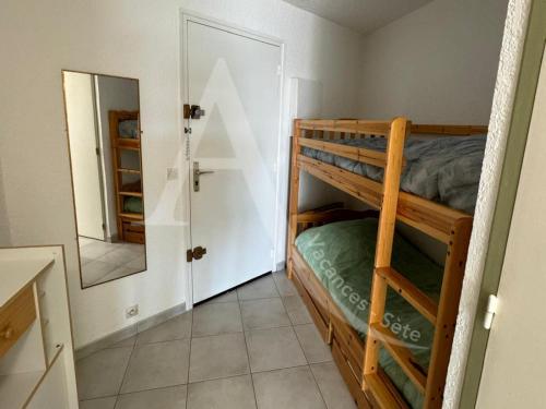 une chambre avec deux lits superposés et un miroir dans l'établissement Studio vue mer avec parking, à Sète