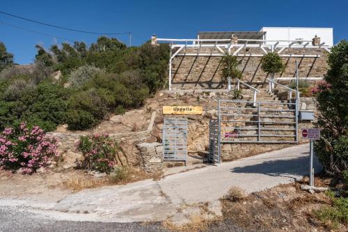a building on a hill with a sign on it at Κατοικία Uppolis με θέα τα νησιά in Ano Syros