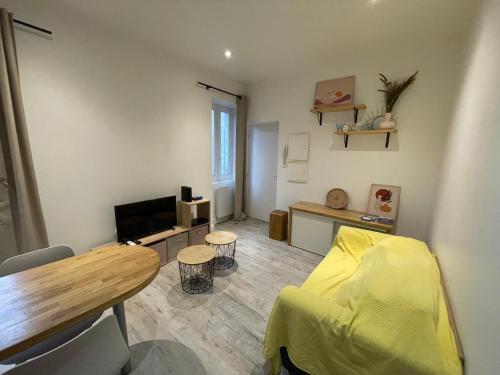 - un salon avec un lit jaune et une table dans l'établissement L'éphémère, à Quimper