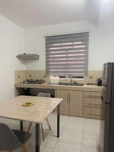 una cucina con un tavolo e una finestra di Santa Studio a La Gaulette