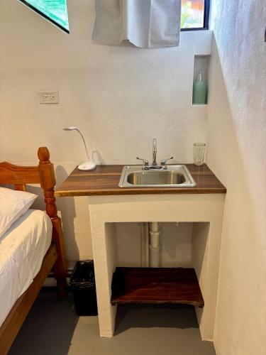 a bathroom with a sink next to a bed at Stella Mar Oceanfront Hotel in Popoyo