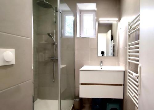 une salle de bain blanche avec un lavabo et une douche dans l'établissement L'Amazone, à Saint-Georges-de-Didonne