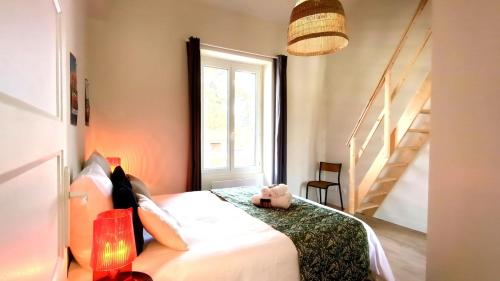 une chambre avec un lit avec un ours en peluche dessus dans l'établissement L'Amazone, à Saint-Georges-de-Didonne