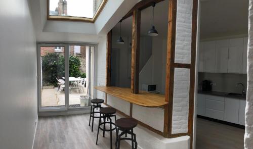 une cuisine avec un comptoir et des tabourets dans une pièce dans l'établissement Le Saint-Honore 6 chambres pour 7 Personnes Stationnement gratuit dans la rue, à Amiens