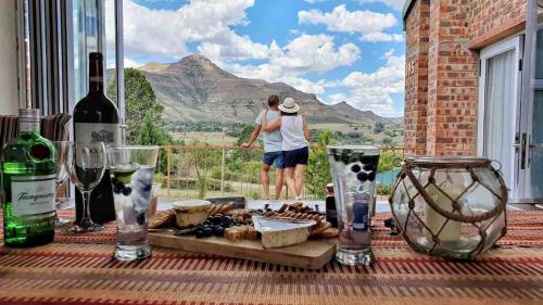 a table with wine bottles and a plate of food at The Lookout, 195 Bester Street, Clarens in Clarens