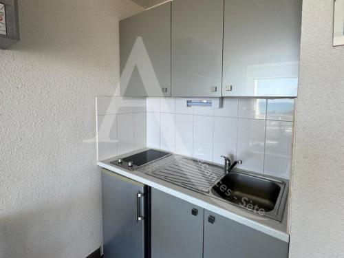 une cuisine avec un évier et un plan de travail dans l'établissement Studio vue mer avec place de parking, à Sète