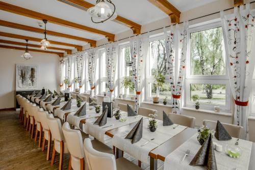 a row of tables in a room with windows at Kaiserhof Feldberg in Feldberg
