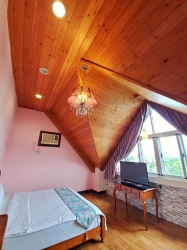 a bedroom with a bed and a desk in a attic at Pulicity Villa B&B in Puli