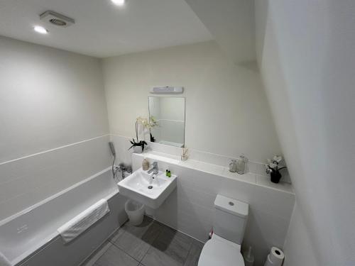 a white bathroom with a toilet and a sink at Willow Warbler - HM112 - Lower Mill Estate Penthouse Apartment with Spa Access in Somerford Keynes