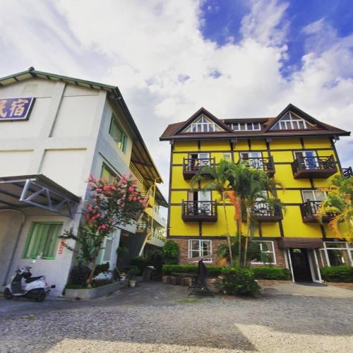 a yellow building next to a white building at Pulicity Villa B&B in Puli