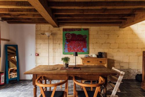 a dining room table with chairs and a painting on the wall at De Zwarte Stok in Riemst