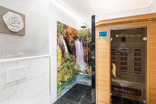ein Bad mit einem Wandbild mit Wasserfall in der Unterkunft 5 Sterne Ferienwohnung Zirbe mit eigener Infrarotsauna und Whirlpoolbadewanne in Arnbruck