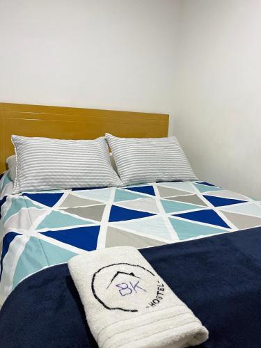 a bed with a blue and white quilt on it at Bogotá Kings 302 in Bogotá