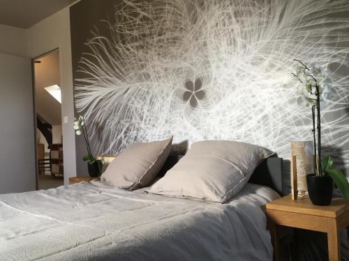 a bedroom with a bed with a flower on the wall at Gite Bonaty in Soulgé-sur-ouette