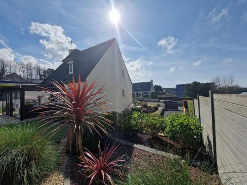 ein weißes Haus mit schwarzem Dach im Hof in der Unterkunft Maison familiale - Côte de Granit Rose in Saint-Quay-Perros