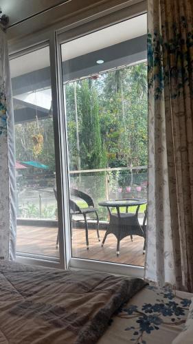 an open sliding glass door with a table and a patio at Lotus Exotica Homestay in Suntikoppa