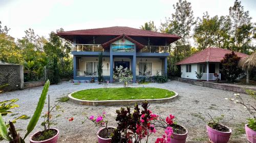 a house with a garden in front of it at Lotus Exotica Homestay in Suntikoppa
