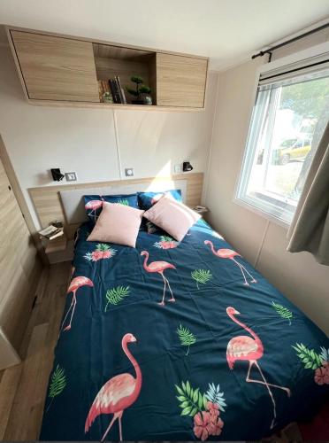 - une chambre avec un lit orné de flamants roses dans l'établissement Mobil Home Bleu ‘n’ Blue, à Canet