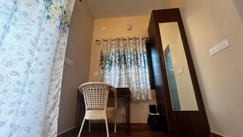 a room with a mirror and a table and a chair at Lotus Exotica Homestay in Suntikoppa