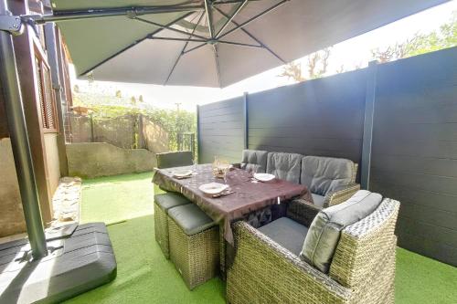 une table et des chaises avec un parasol sur une terrasse dans l'établissement Vanessa - 200m from the beach Terrace - by TGB, à Appietto