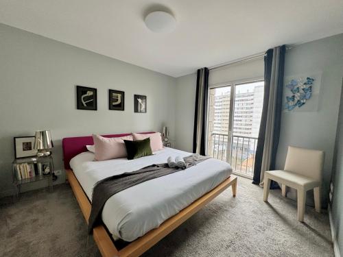 une chambre avec un grand lit et une fenêtre dans l'établissement L'Aristide, Centre de Rennes avec vue Vilaine, à Rennes