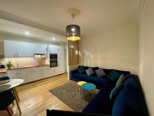a living room with a blue couch and a kitchen at Appartement Porte de Versailles Olivier de Serre in Paris