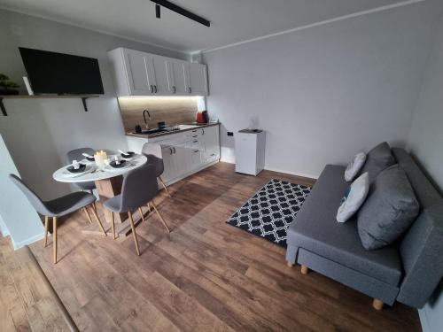 a living room with a couch and a table and chairs at Serenity Ház in Odorheiu Secuiesc