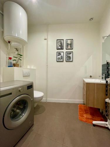 une salle de bain avec machine à laver et toilettes dans l'établissement Appartement Porte de Versailles Olivier de Serre, à Paris