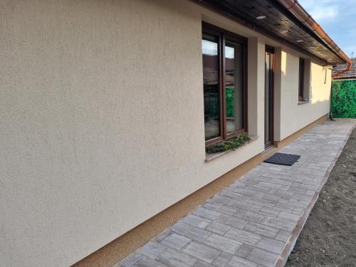 a house with a brick walkway next to a building at Serenity Ház in Odorheiu Secuiesc