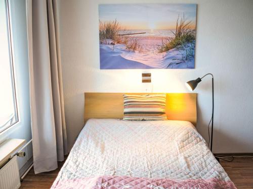 a bedroom with a bed and a painting on the wall at Apartment Ostsee-Residenz - DMP173 by Interhome in Damp
