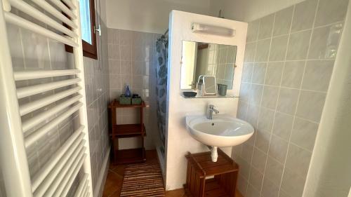 une petite salle de bain avec un lavabo et un miroir dans l'établissement Villa familiale située à 10 minutes à pieds de la plage de Santa Giulia, à Porto-Vecchio