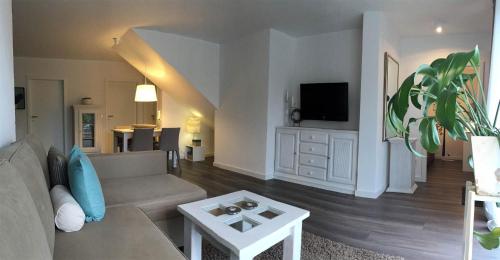 a living room with a couch and a tv at Ferienapartment am Möhnesee in Möhnesee