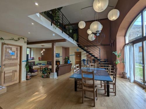 ein Esszimmer mit Tisch und Stühlen und einer Treppe in der Unterkunft Surlechemin Marielle - Gite 30min Grenoble in Tullins
