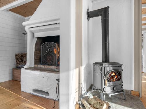 a fireplace in a living room with a stove at Holiday Home Haven by Interhome in Birkeland