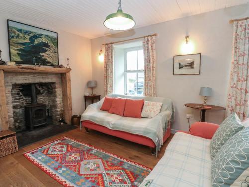 a living room with a couch and a fireplace at Woodland Cottage in Arisaig