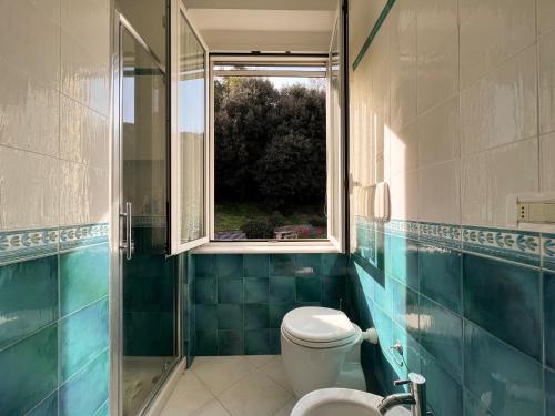 a bathroom with a toilet and a window at Appartamento Golf in Lerici