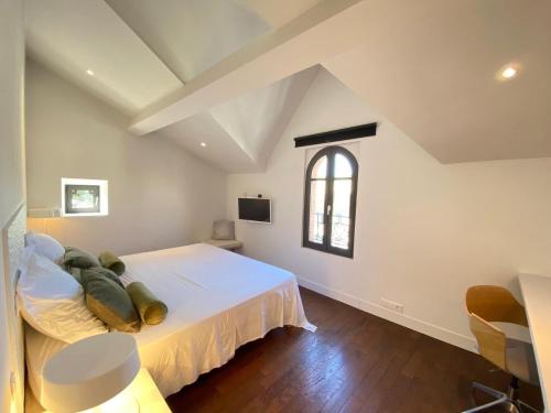 une chambre avec un grand lit blanc et une fenêtre dans l'établissement House Avenue, à Carcassonne