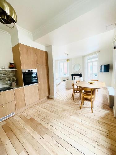 une cuisine et une salle à manger avec une table et des chaises en bois dans l'établissement Appartement terrasse vue cathédrale centre ville, à Reims
