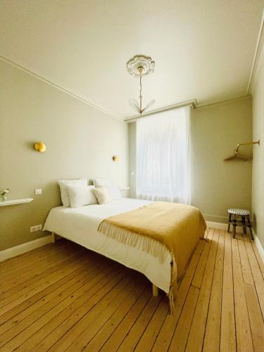 une chambre avec un grand lit et une fenêtre dans l'établissement Appartement terrasse vue cathédrale centre ville, à Reims