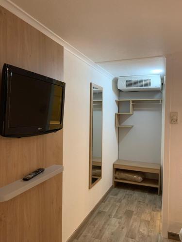 a room with a flat screen tv on a wall at Kyriad SEDAN in Sedan