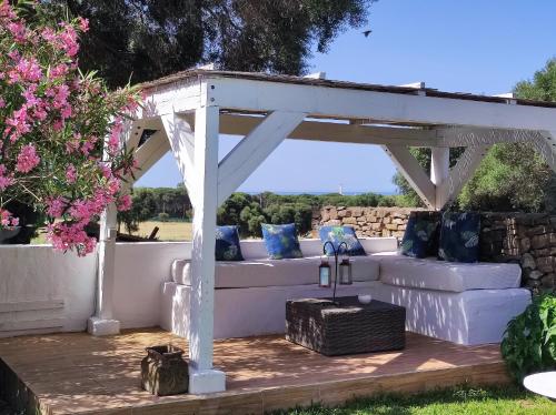 a white pergola with a white couch on a wooden deck at Casa Rural Maximón Apartamento Azul in Los Caños de Meca