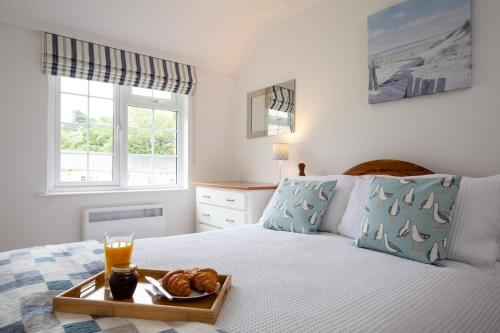 a bedroom with a bed with a tray of food on it at Beautiful Cottage nr Perranporth Private Parking in Perranzabuloe