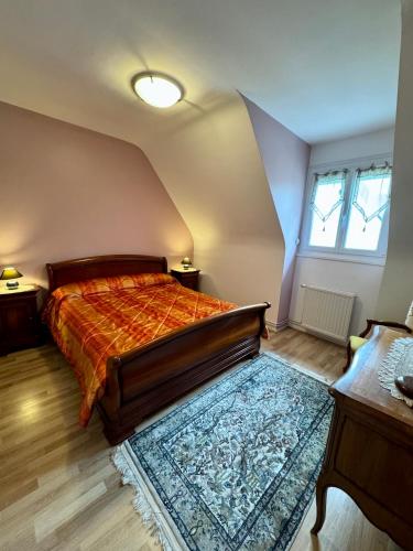 - une chambre avec un lit doté d'un couvre-lit orange et d'un tapis dans l'établissement Maison familiale - Côte de Granit Rose, à Saint-Quay-Perros